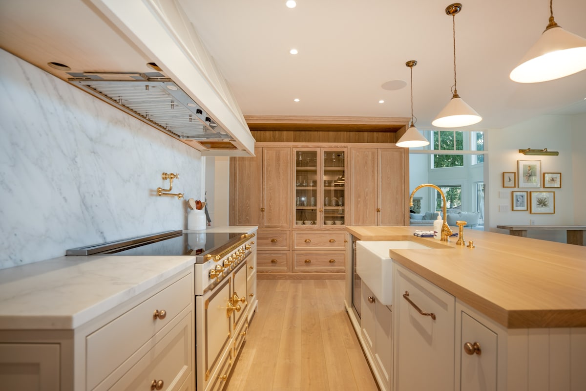Chef's kitchen with La Cornue range, marble backsplash and oak cabinetry