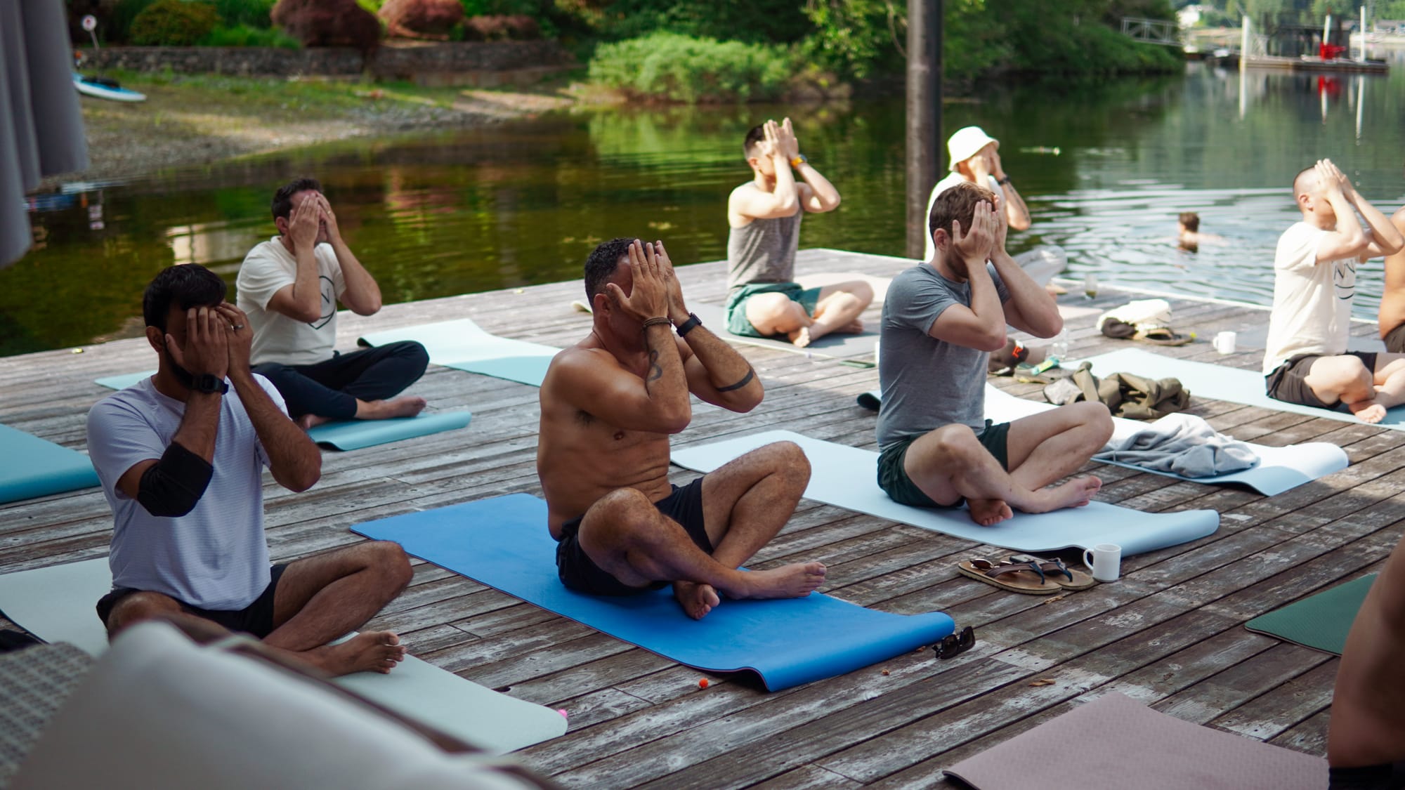 Group meditation session on the lakefront dock at golden hour