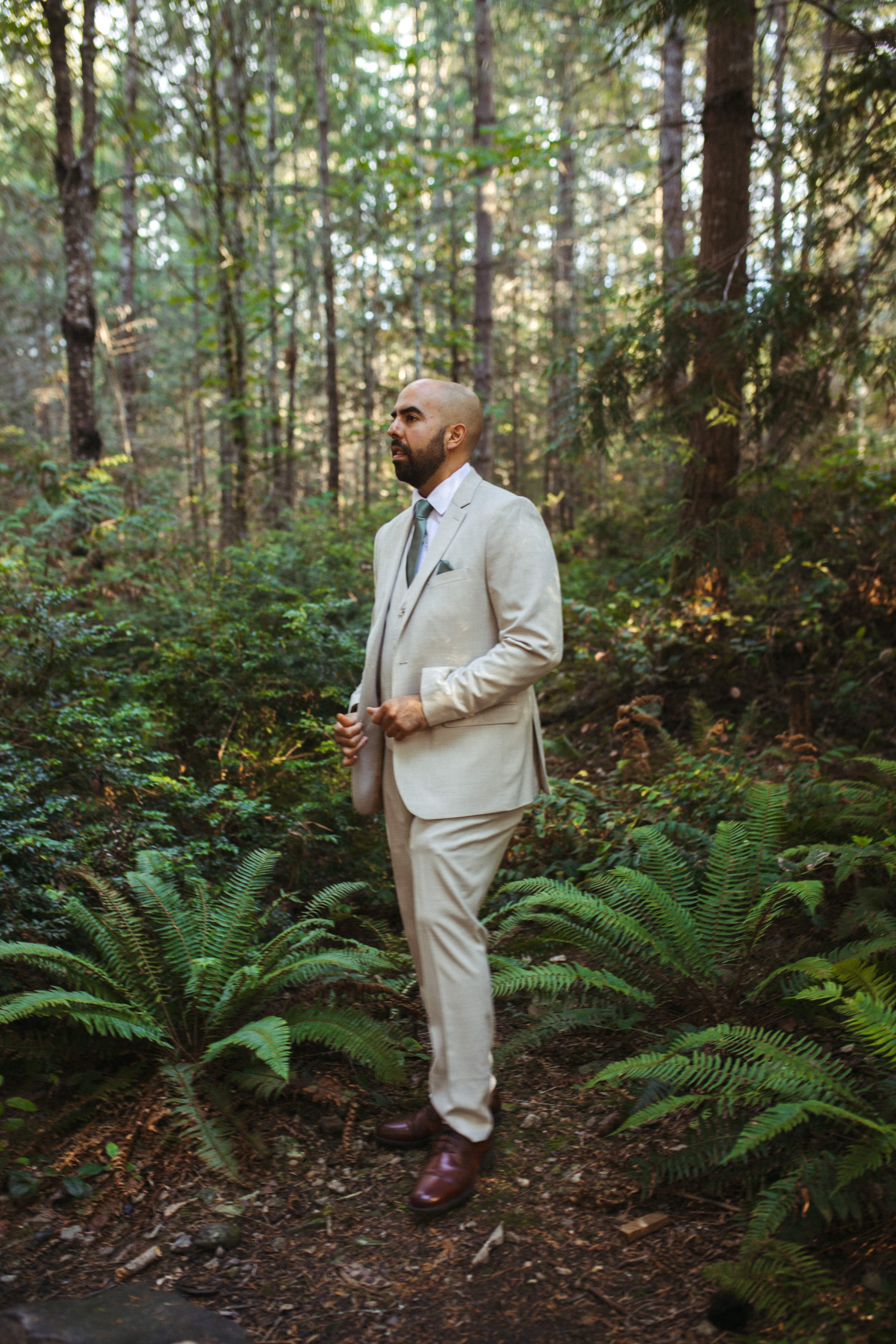 Groom in forest setting before lakefront ceremony